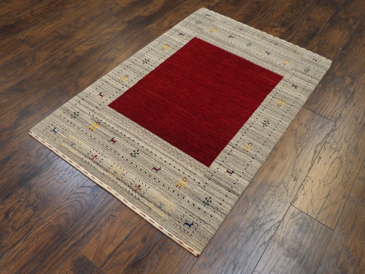 Gabbeh tribal motif detail, beige and red rug