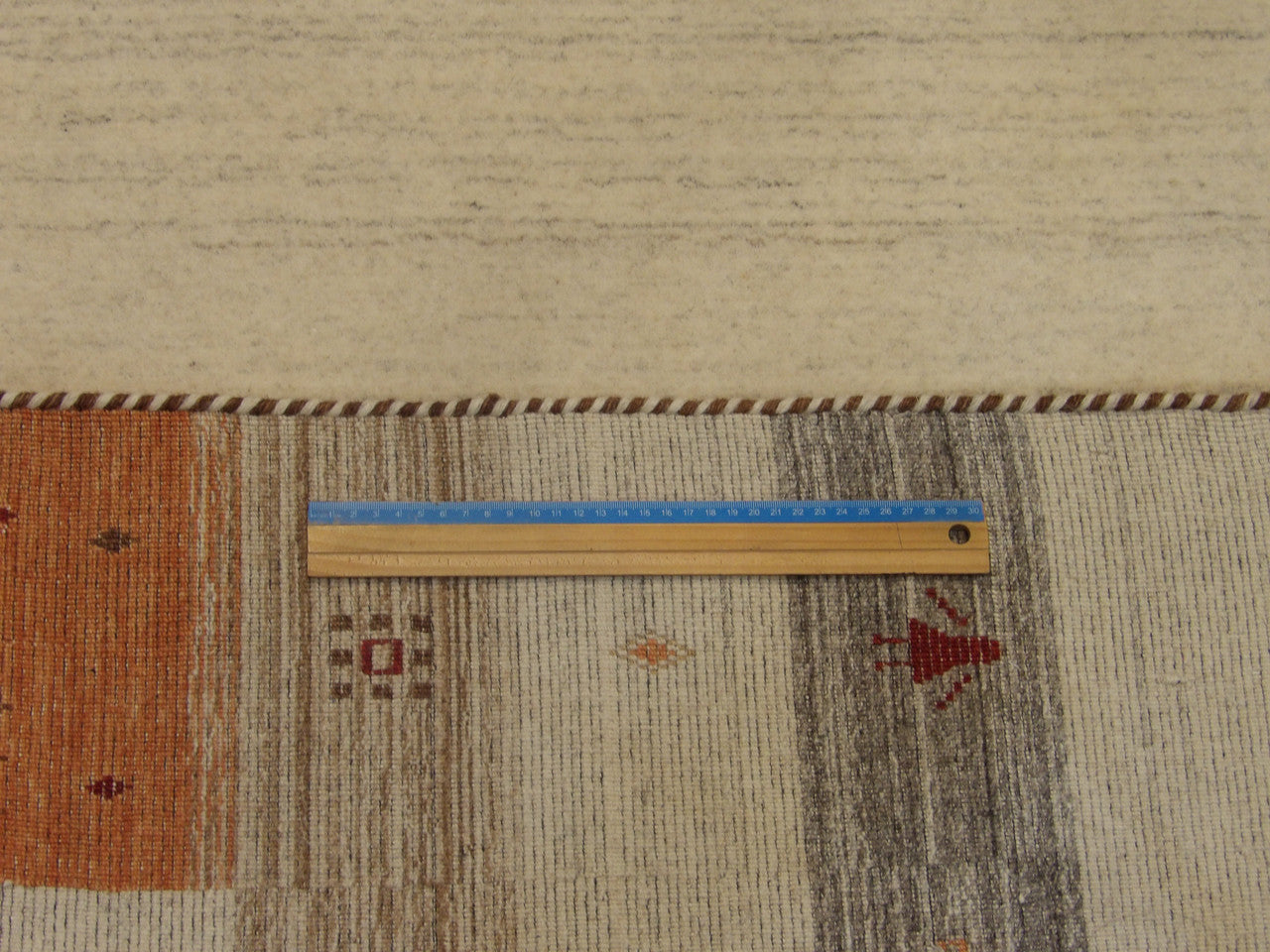 Ivory and rust Gabbeh rug in room setting