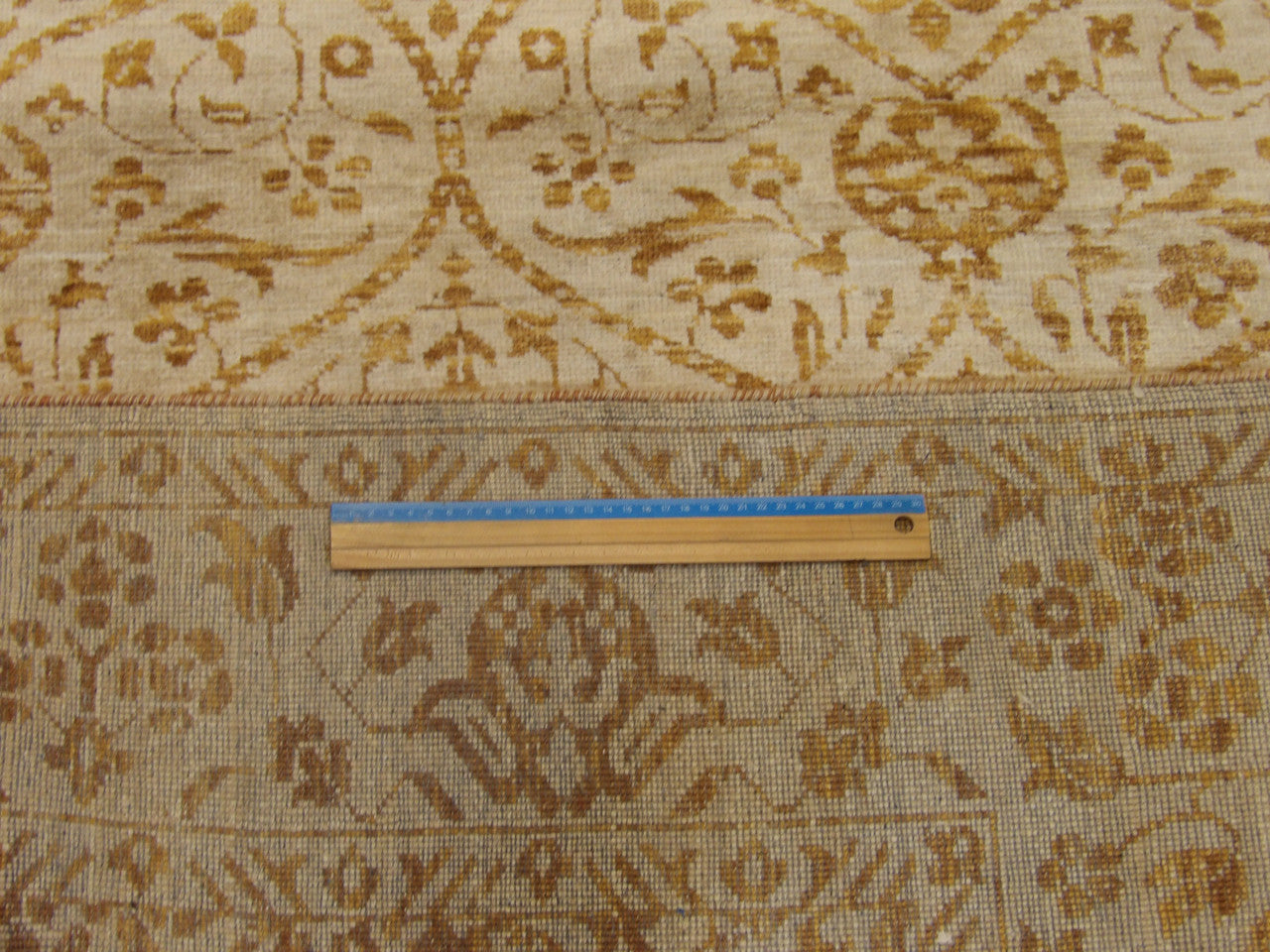 Brown and gold damask rug in room setting