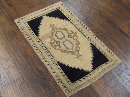 Antique beige and black Yastik rug in a small accent setting