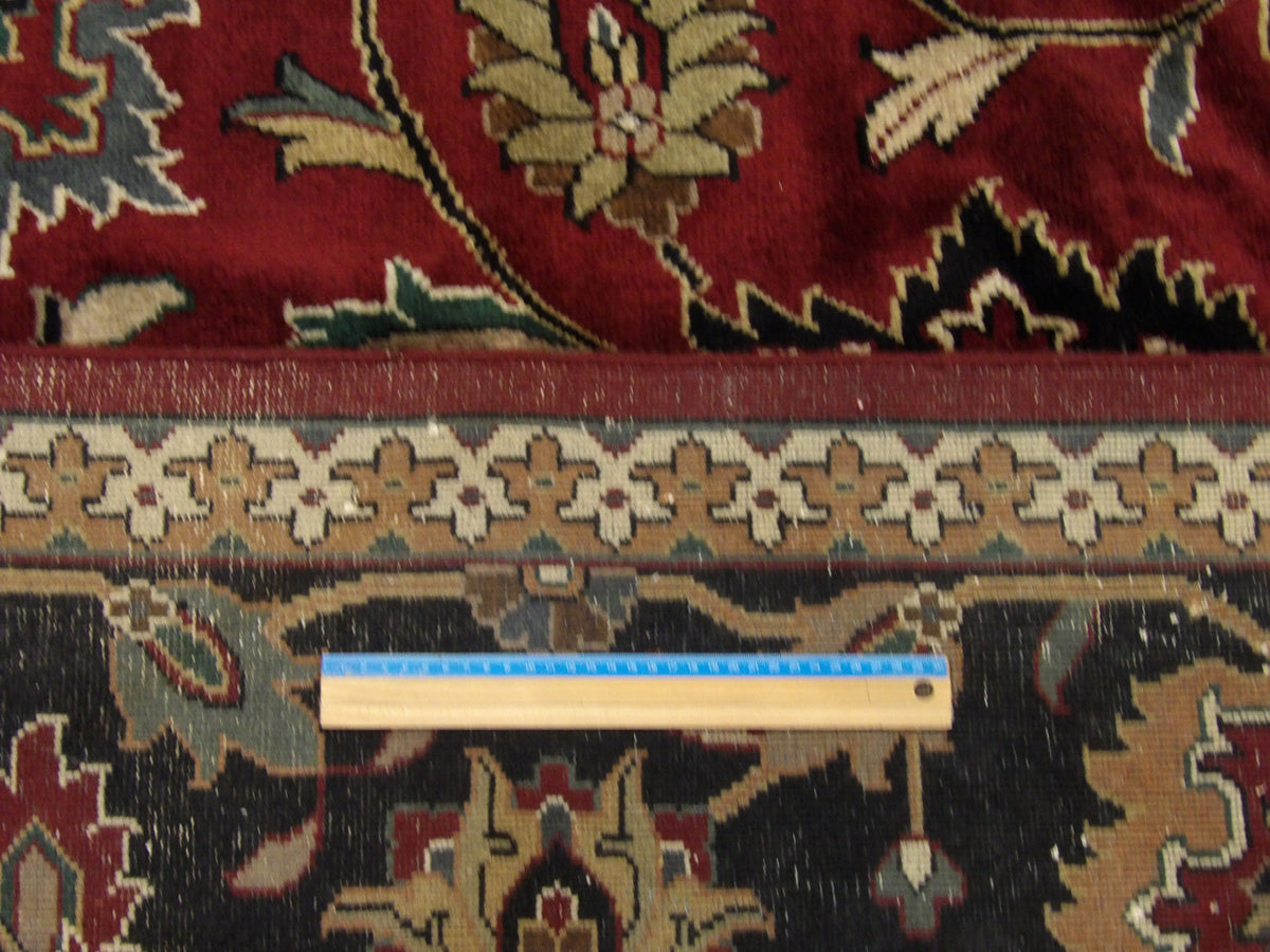 Black and red antique Kashan rug in room setting