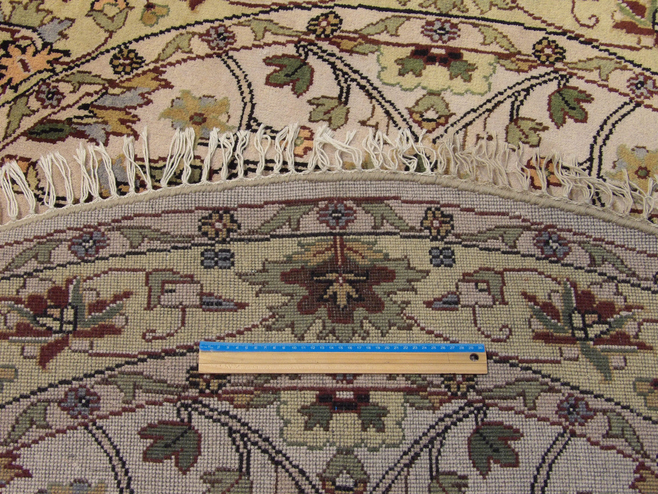 Beige and gold Ziegler round rug in room setting