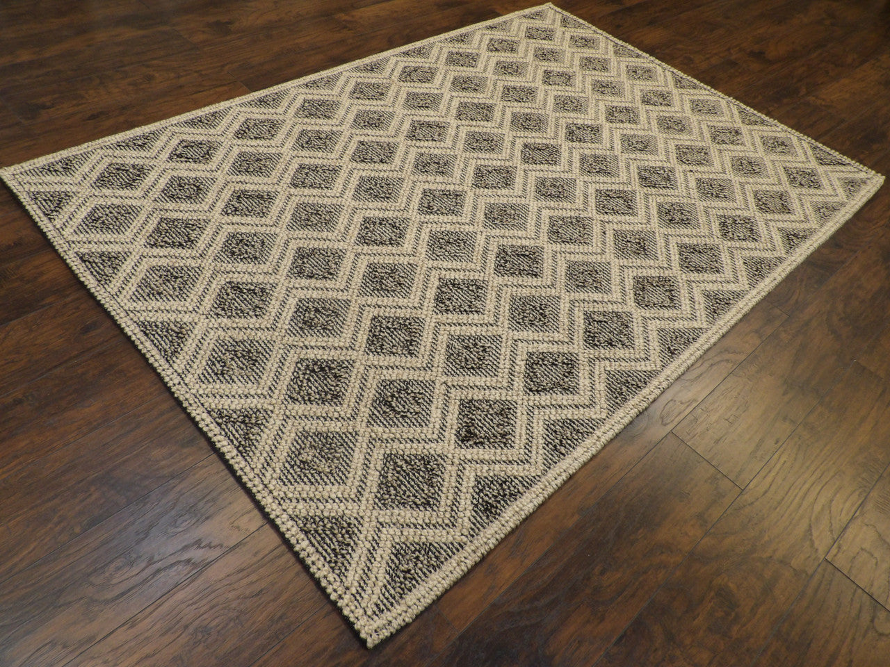 Braided geometric pattern detail, black rug