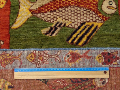 Blue and rust fish design rug in room setting
