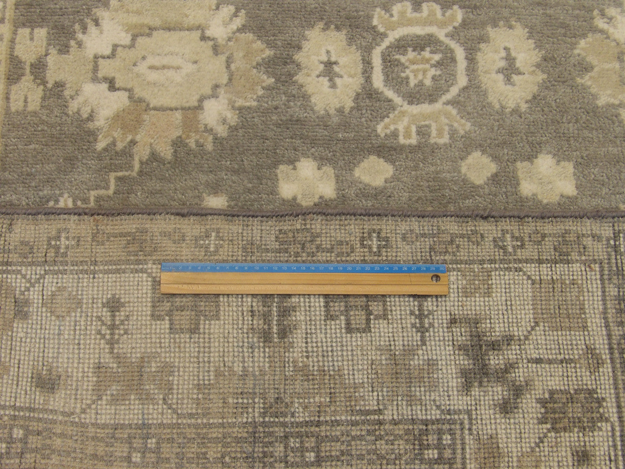 Gray and ivory Oushak rug in room setting