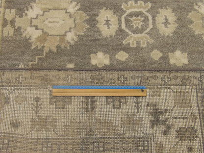 Gray and ivory Oushak rug in room setting