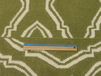 Green and white coastal rug in room setting