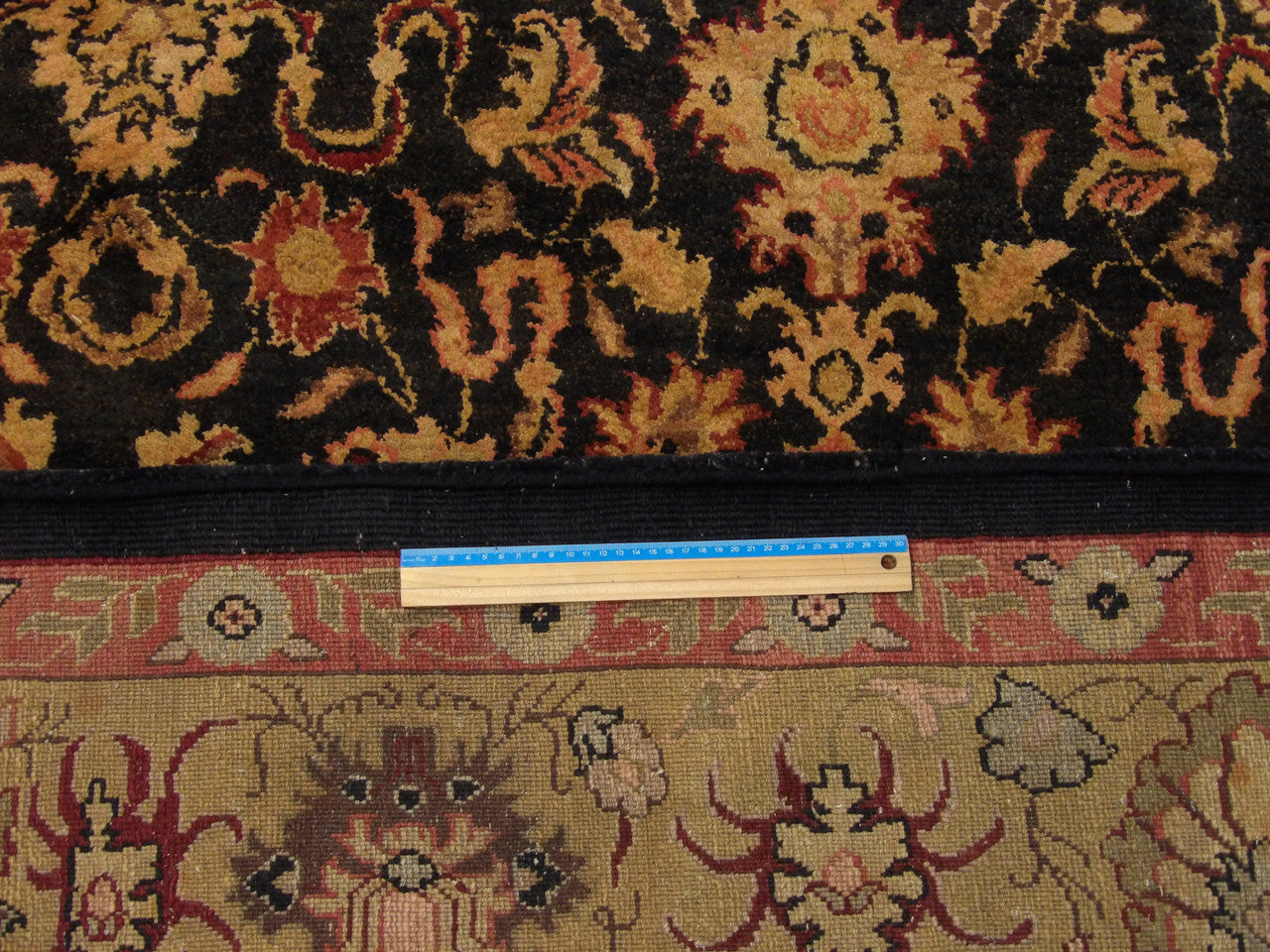Black and gold Kashan rug in room setting
