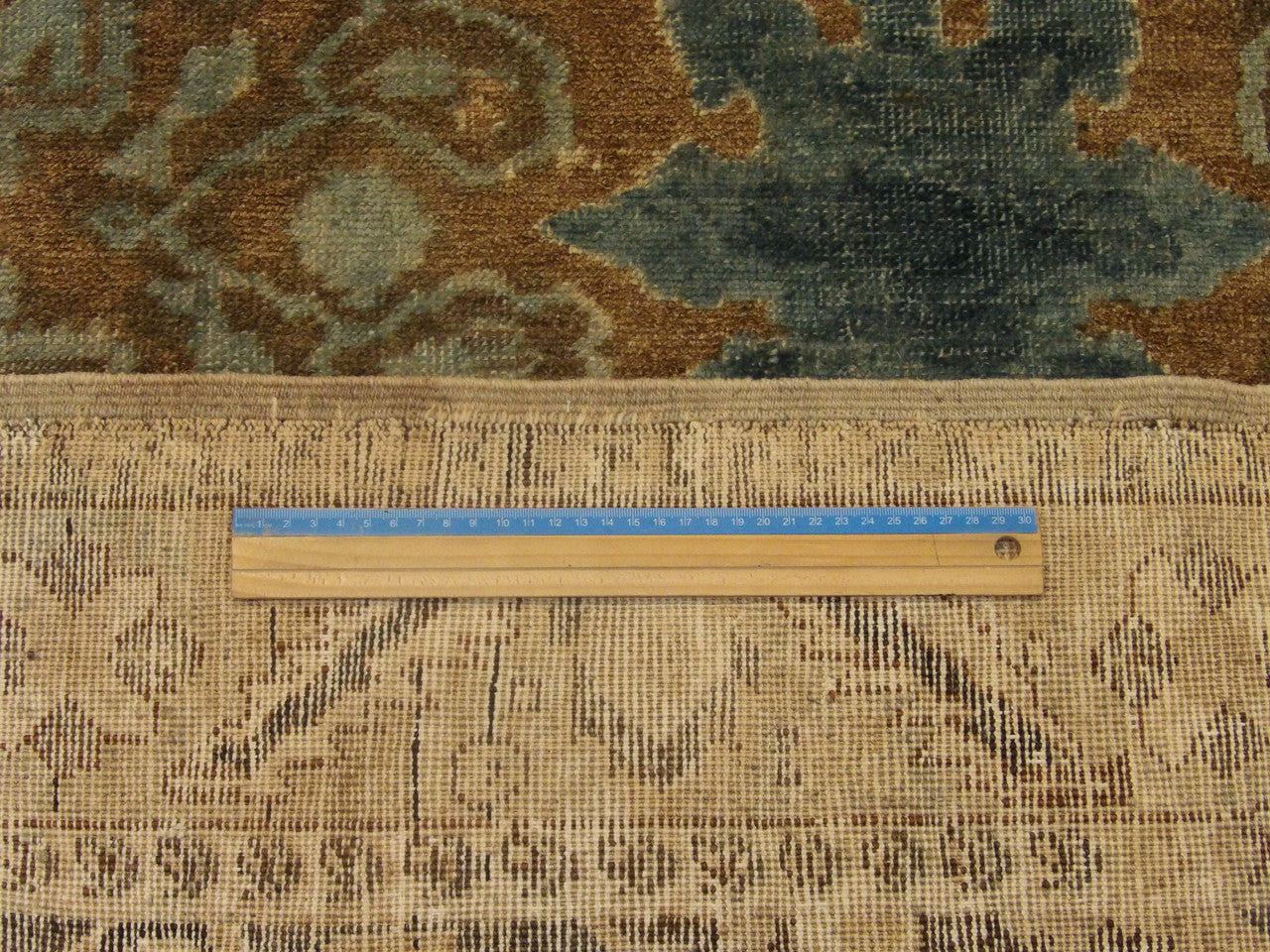 Beige and teal Oushak rug in room setting