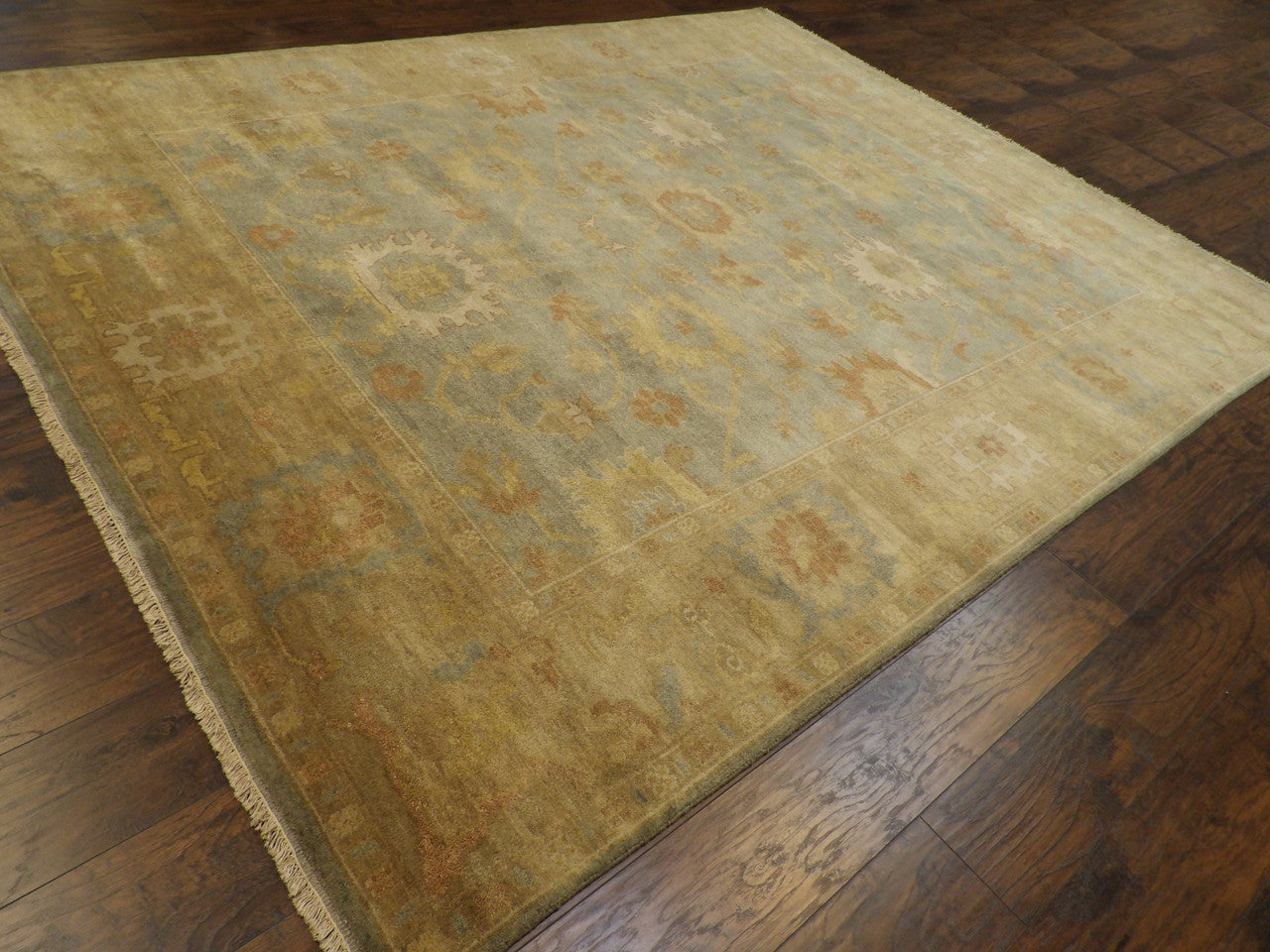 Gold and green Oushak rug in a living room setting