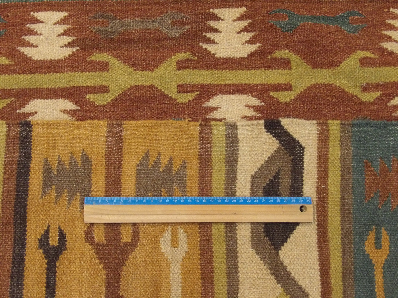 Gold and green coastal rug in room setting