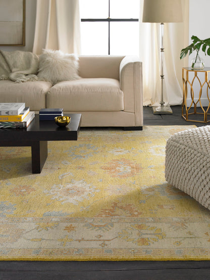 Gold and beige Oushak wool rug in room setting
