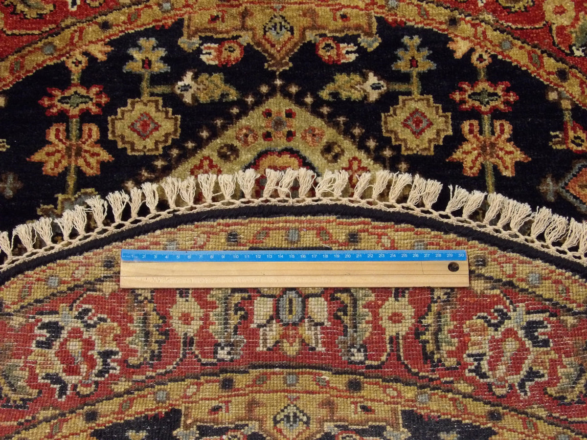 Blue and red Serapi round rug in room setting