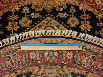 Blue and red Serapi round rug in room setting