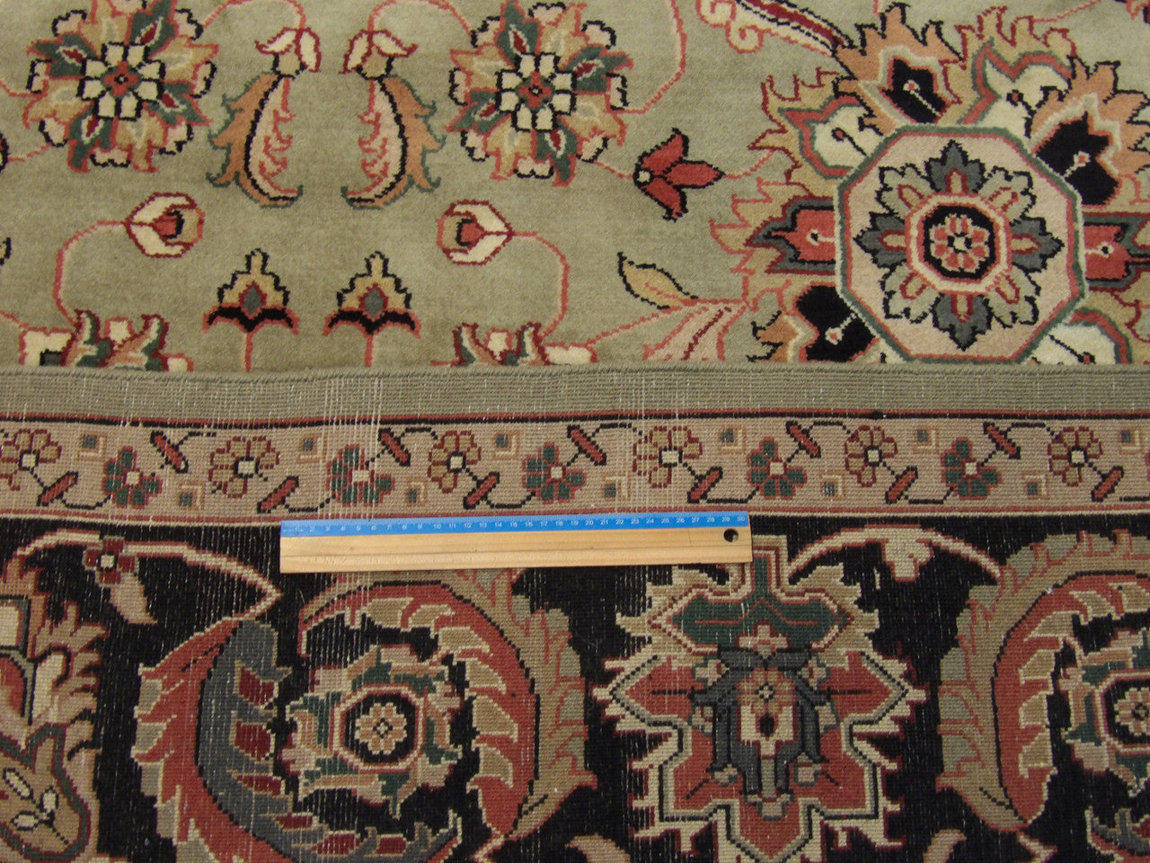 Black and green Mashad rug in room setting