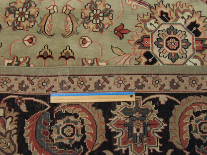 Black and green Mashad rug in room setting