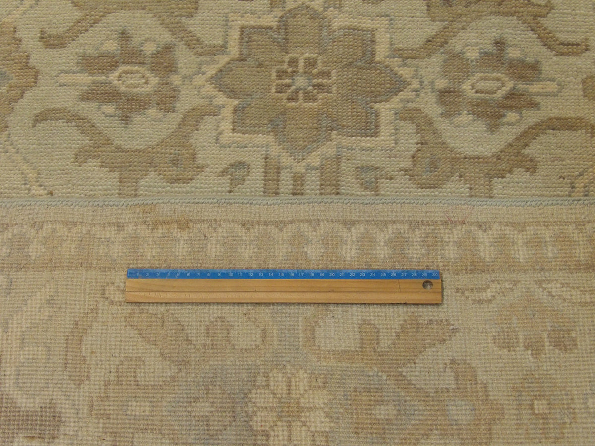 Green and beige Khotan rug in room setting