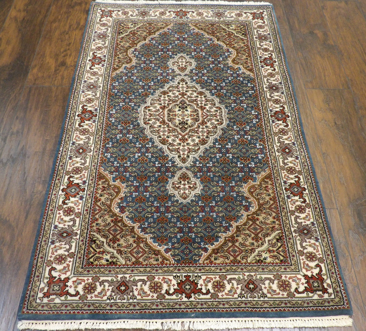 Close-up of wool pile, beige and teal rug
