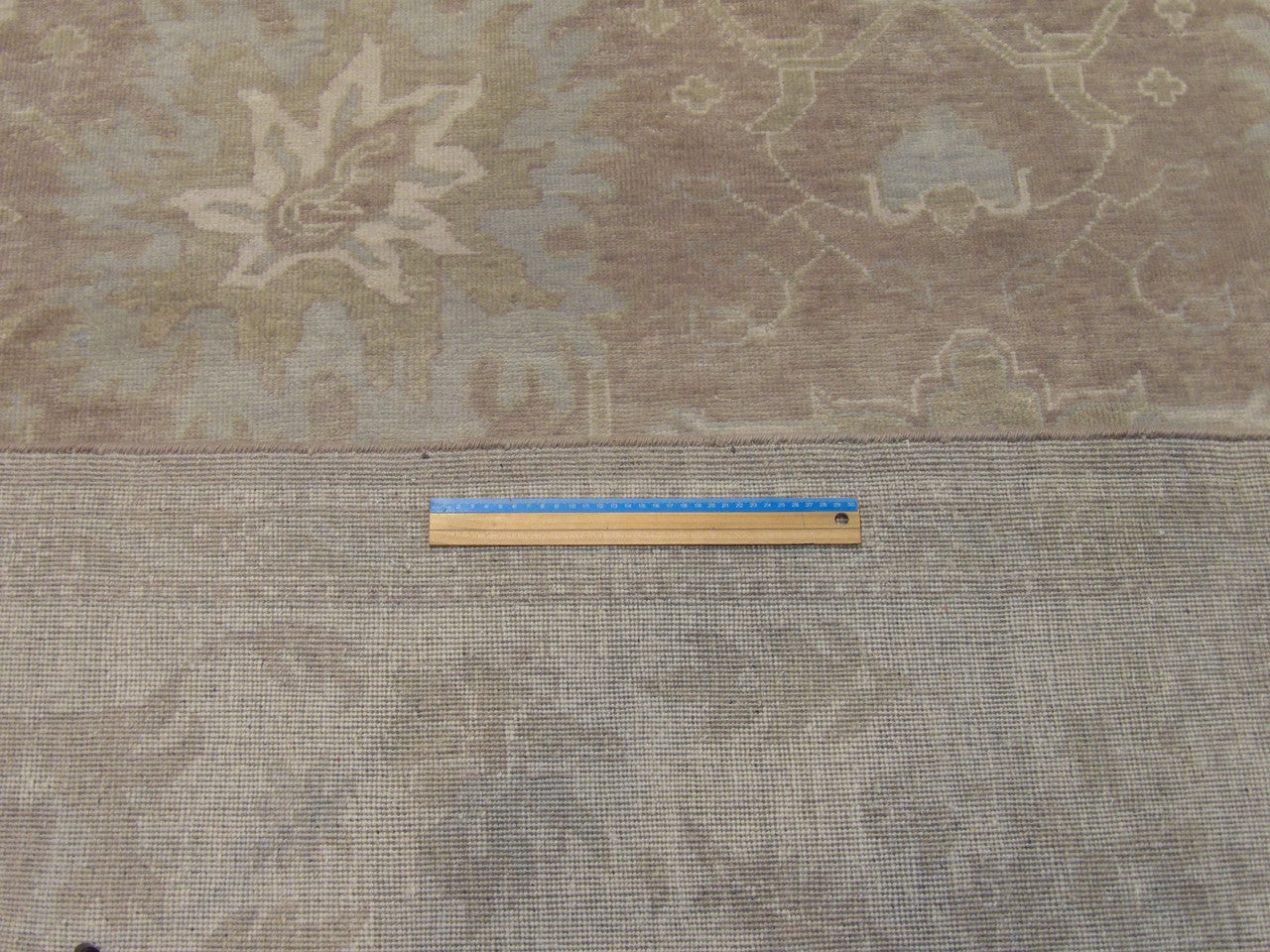 Brown and ivory Oushak rug in room setting