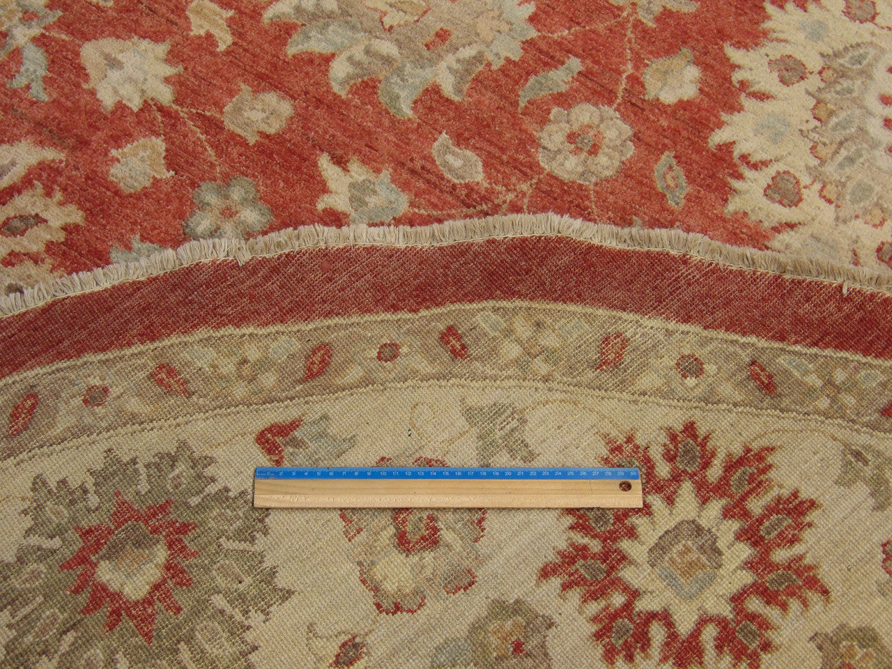 Beige and red Oushak round rug in room setting