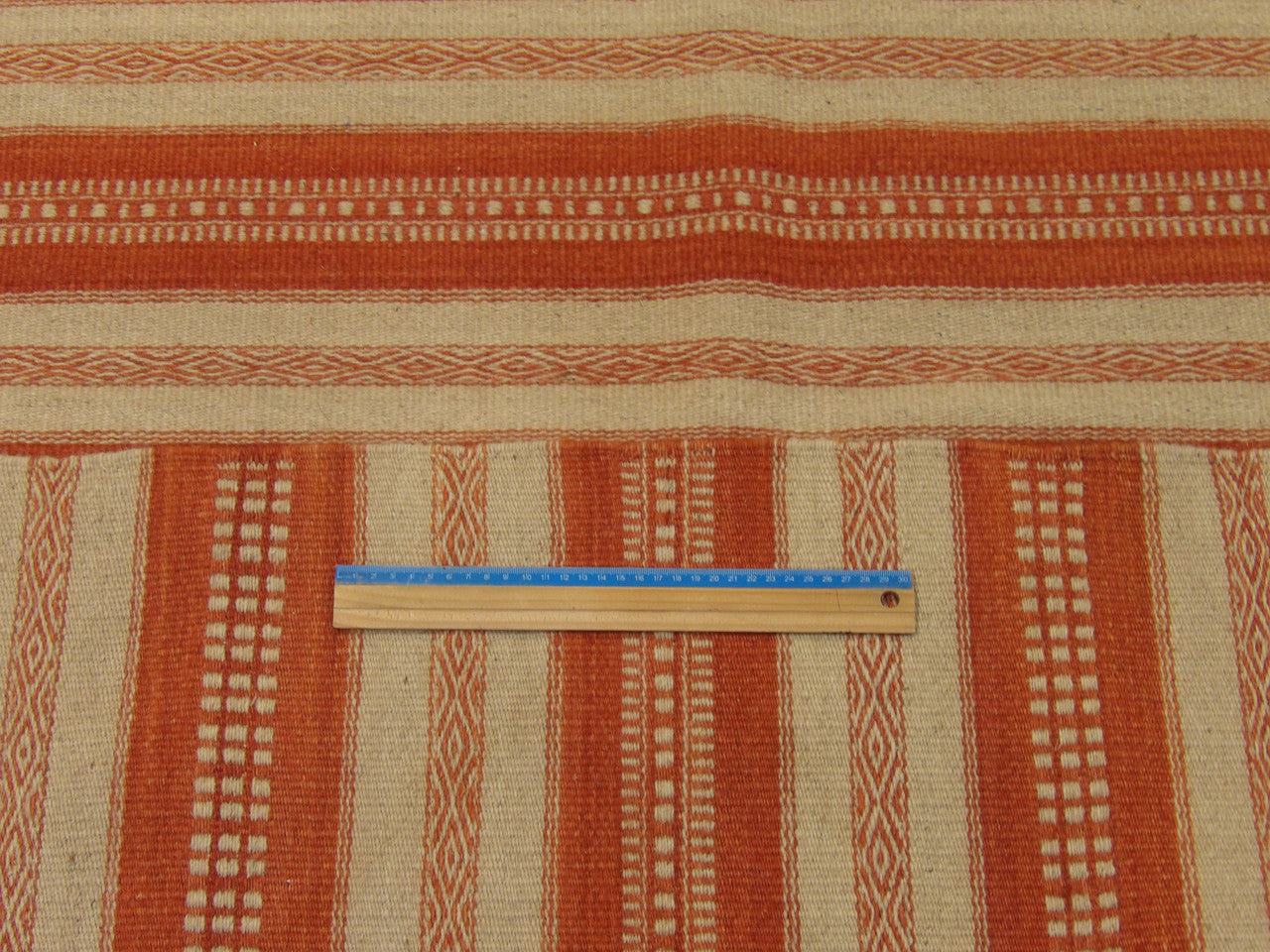 Beige and red coastal rug in room setting