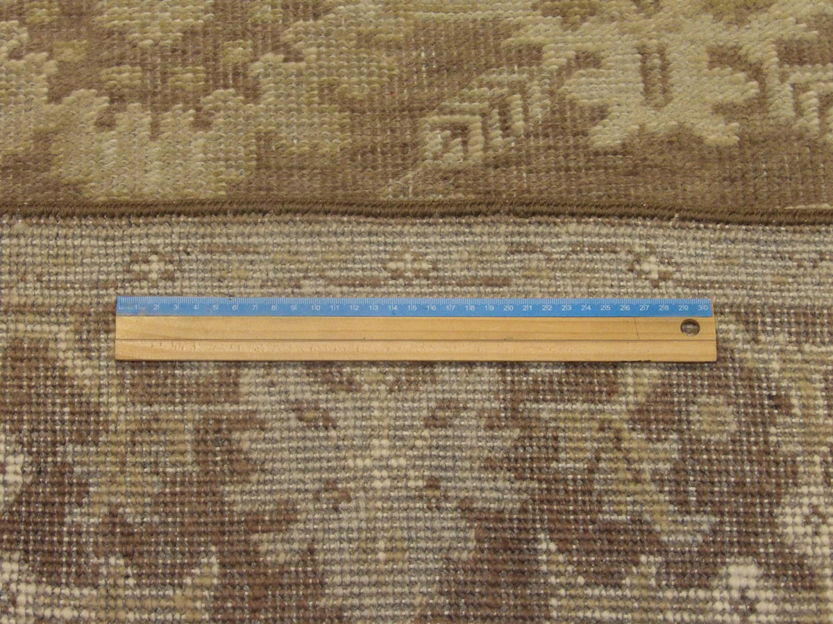 Brown and green Oushak rug in room setting