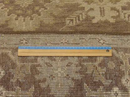Brown and green Oushak rug in room setting