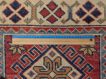 Beige and red Kazak rug in room setting