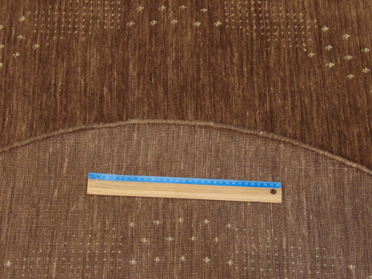 Brown and beige Gabbeh round rug in room setting