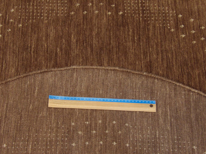 Brown and beige Gabbeh round rug in room setting