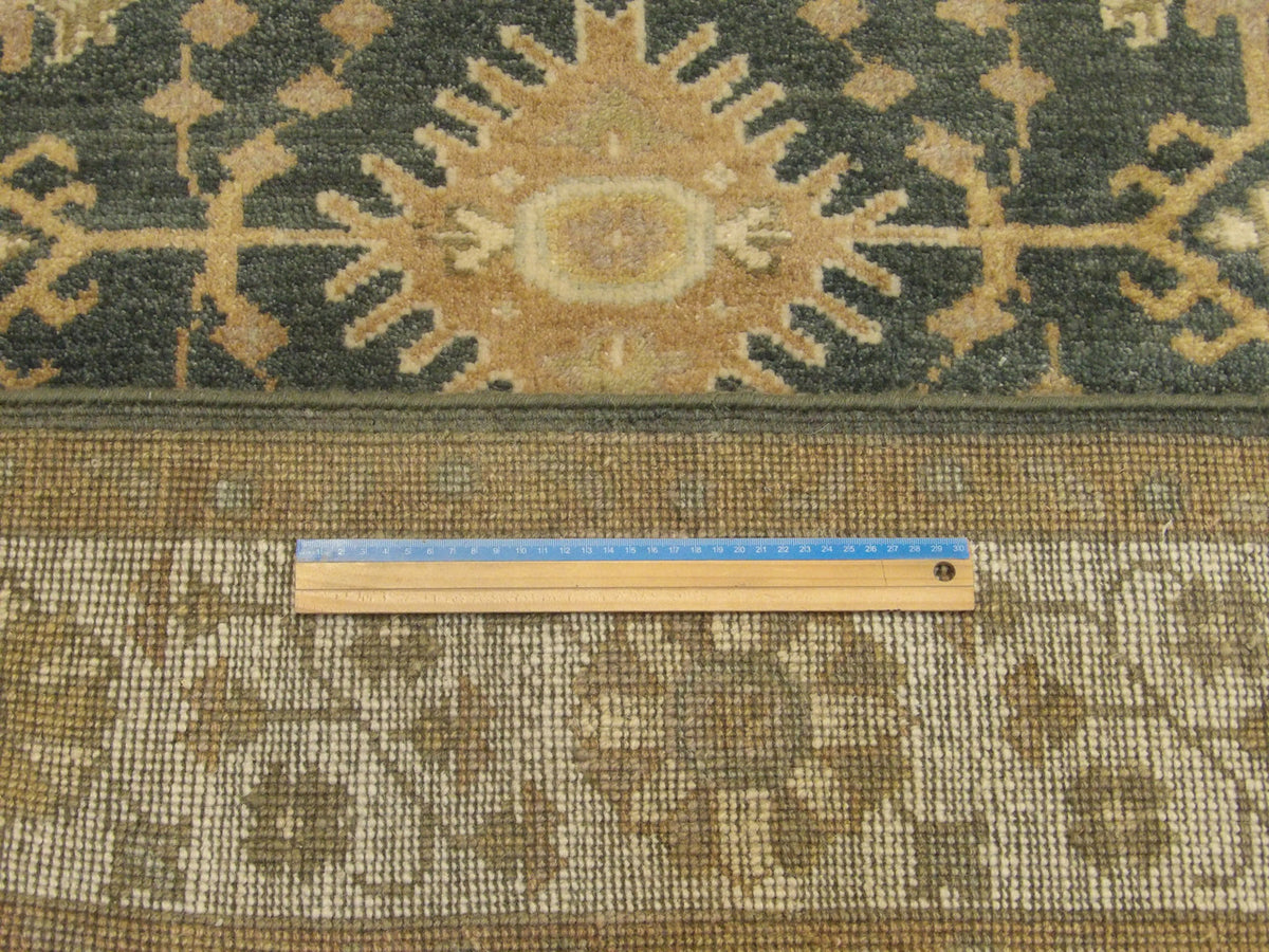 Green and beige Oushak rug in room setting