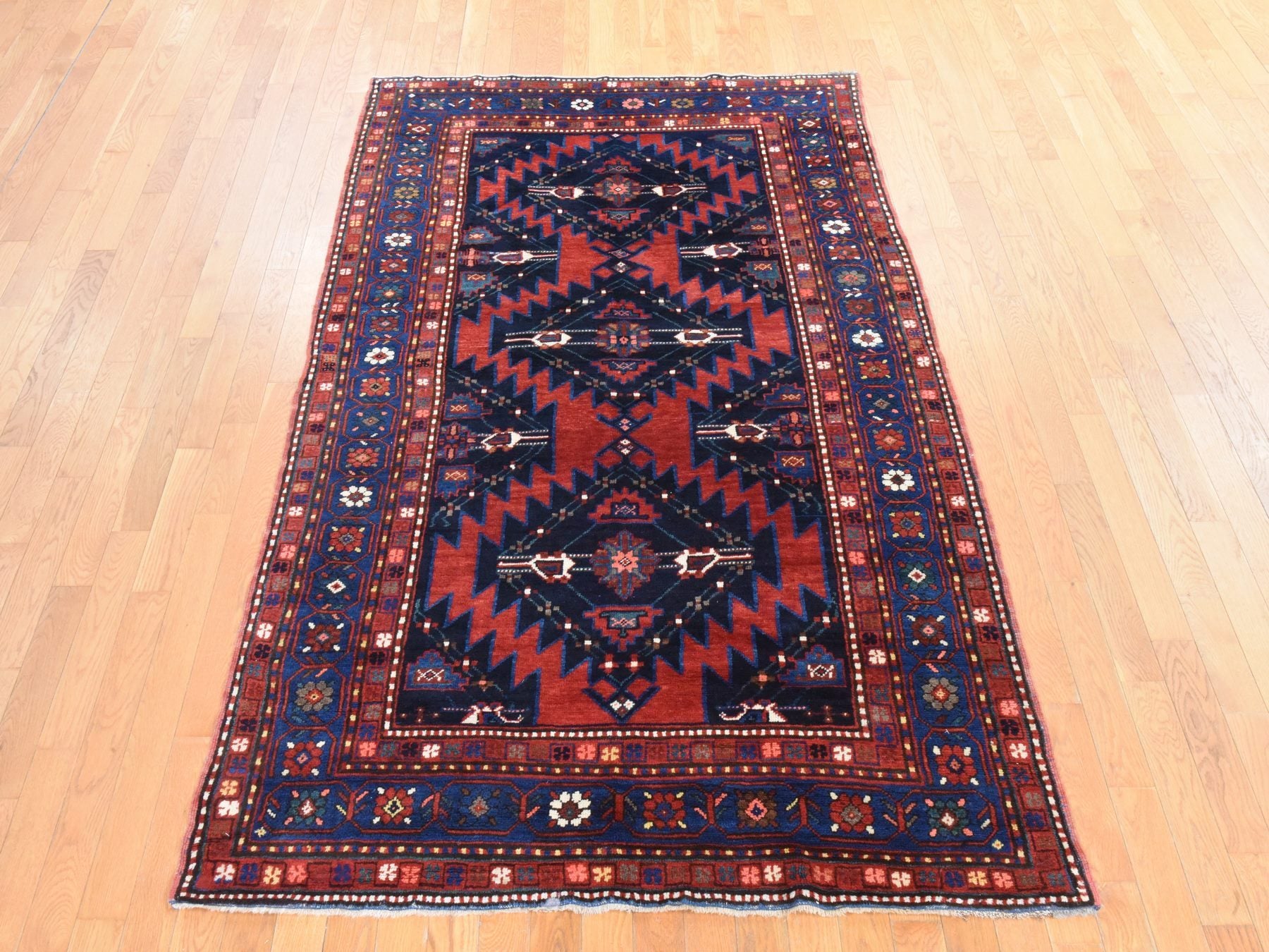 Antique hand-knotted wool rug in Red & Navy Blue, 5' x 8'6" — SKU O078487 (view 2)